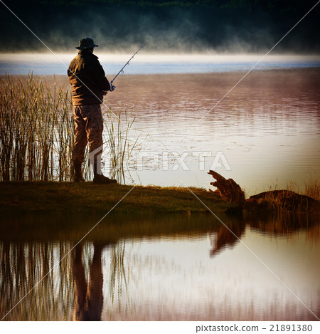 Lone fisherman catches fish Lone fisherman catches fish 21891380