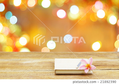 notebook and flower on wooden table 21892390