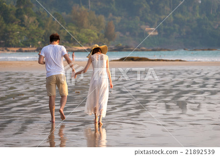 Young couple Enjoying walking on the beach 21892539