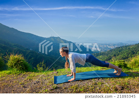 Woman doing Hatha yoga asana plank pose outdoors Woman doing Hatha yoga asana plank pose outdoors 21893345