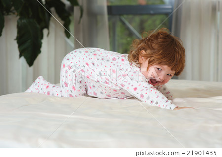 Happy red-haired baby on the bed Happy red-haired baby on the bed 21901435