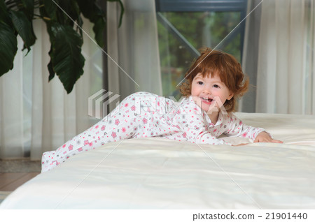 Happy red-haired baby on the bed Happy red-haired baby on the bed 21901440