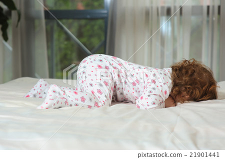 Happy red-haired baby on the bed 21901441