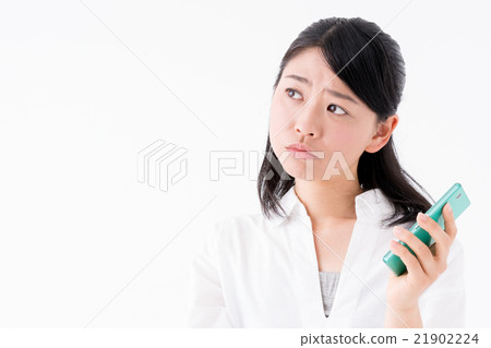 A woman with a troubled face holding a smartphone 21902224