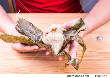 Hand unwrapping Chinese rice dumpling or zongzi 21904644