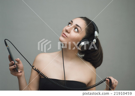 Woman with headphones and listening to music on a 21910459