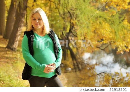 Pregnant woman posing in autumn park 21918201