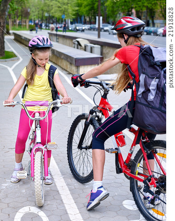 Girls children cycling on yellow bike lane. Girls children cycling on yellow bike lane. 21918828