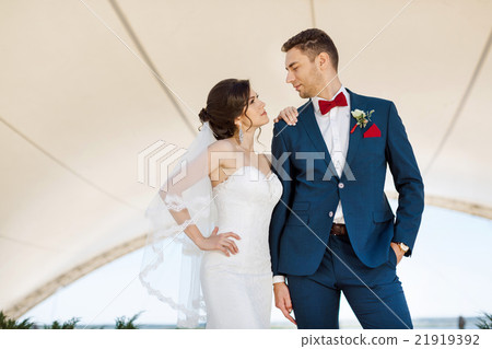 Young wedding couple standing outdoors 21919392
