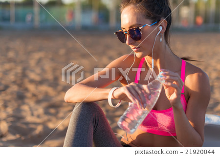 Beautiful fitness athlete woman drinking water Beautiful fitness athlete woman drinking water 21920044