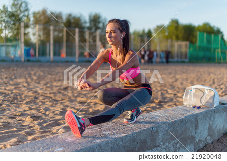 Fitness model athlete girl warm up stretching her 21920048