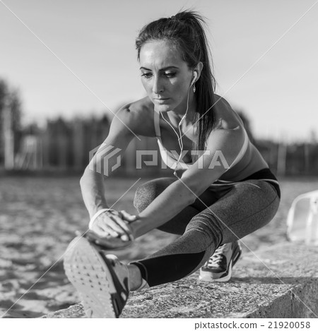 Fitness model athlete girl warm up stretching her 21920058