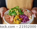 A woman giving an appetizer salad with both hands 21932000