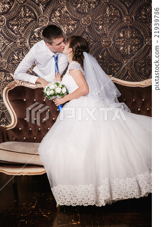 Kiss of the groom and bride in studio 21939786