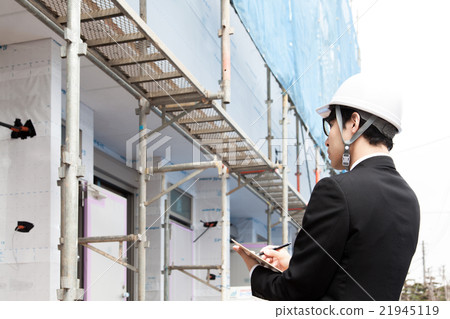 一個男子戴著頭盔檢查建築物 一個男子戴著頭盔檢查建築物 21945119