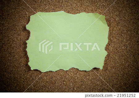 Crumpled yellow sticky note on cork board. 21951252