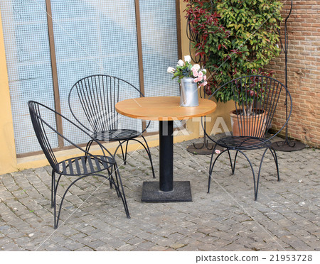 wood tables and black chairs outside cafe wood tables and black chairs outside cafe 21953728