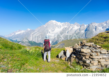 Backpacker hiking on the Alps, majestic Mont Blanc in background Backpacker hiking on the Alps, majestic Mont Blanc in background 21954652