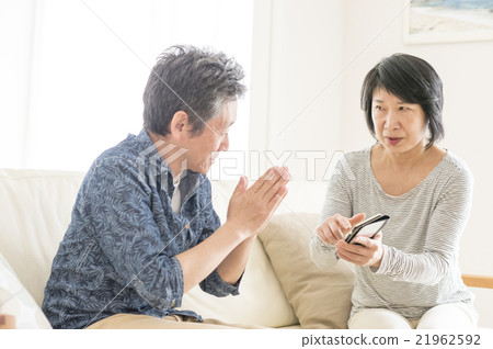 An angry woman and a worried men looking at the screen of the smartphone 21962592