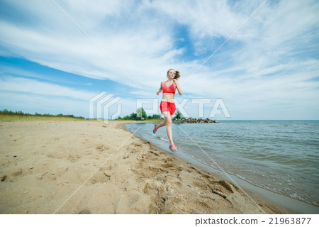 Young lady running at the sunny summer sand beach 21963877