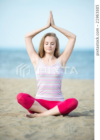 Young lady practicing yoga. Workout near ocean sea 21963885