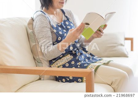 中部在沙發的年邁的婦女讀書 中部在沙發的年邁的婦女讀書 21968697