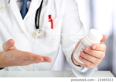 Doctor showing a bottle of pills to the patient Doctor showing a bottle of pills to the patient 21985013