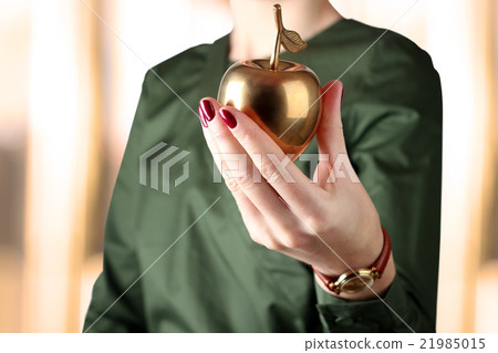 Woman holding golden apple in her hand. 21985015