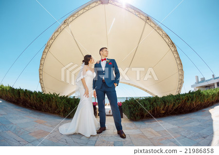 Young wedding couple standing outdoors 21986858