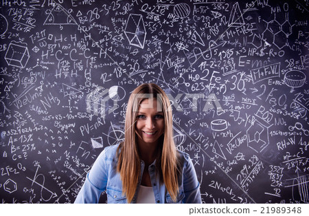 Student against a big blackboard with mathematical Student against a big blackboard with mathematical 21989348