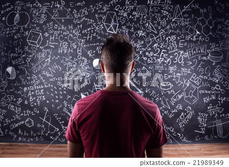 Student against a big blackboard with mathematical Student against a big blackboard with mathematical 21989349