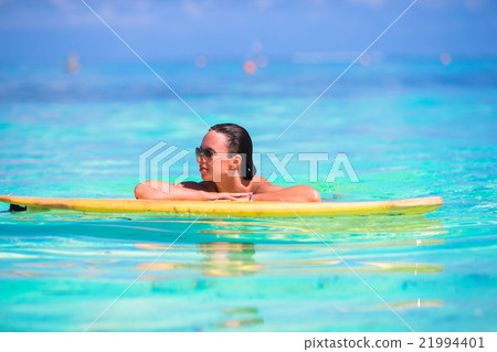Young surfer girl surfing in turquoise sea 21994401