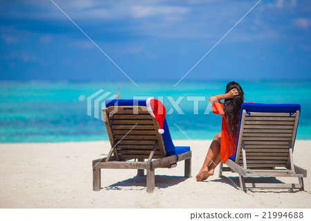 Red santa hat on chair longue at tropical white Red santa hat on chair longue at tropical white 21994688