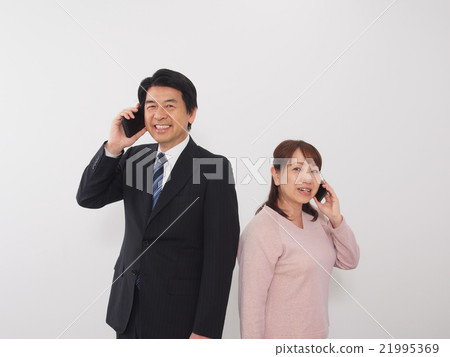 A couple engaged in a telephone call A couple engaged in a telephone call 21995369