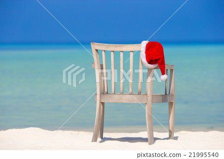 Red santa hat on beach chair at tropical vacation Red santa hat on beach chair at tropical vacation 21995540