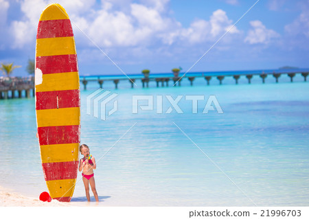 Adorable little girl with big surfboard during 21996703