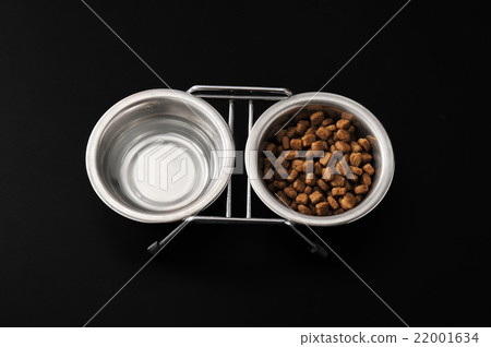 dog food in a metal bowl on black background. dog food in a metal bowl on black background. 22001634