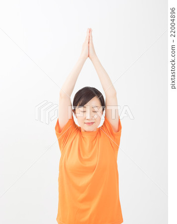A middle woman wearing an orange shirt and doing yoga A middle woman wearing an orange shirt and doing yoga 22004896