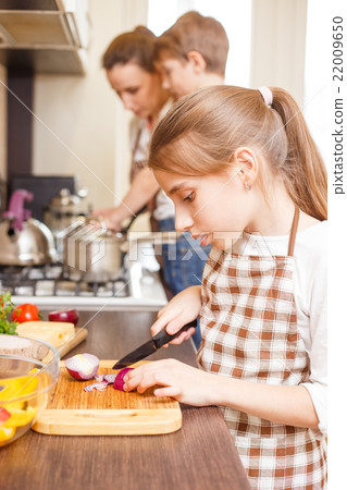 Family cooking background. Teen girl cutting onion 22009650