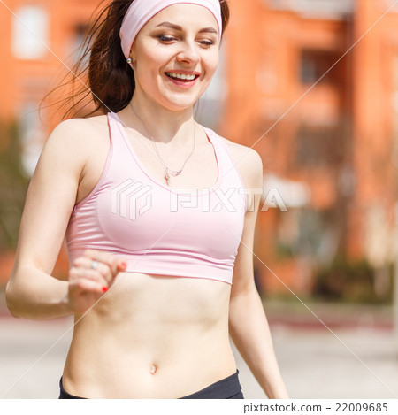 Young happy woman jogging in the street 22009685