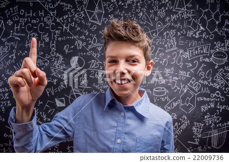 Boy with raised finger against big blackboard with 22009736