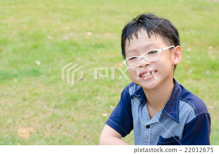 Young Asian boy smiling in park Young Asian boy smiling in park 22012675