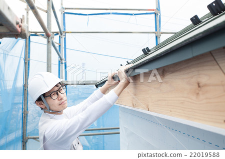 Workers at the construction site working on the scaffolding of the roof 22019588