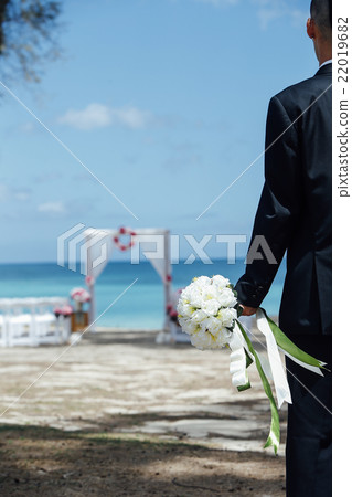 A groom walking on the beach A groom walking on the beach 22019682