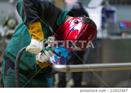 Industrial worker welding in metal factory. 22022867