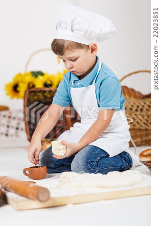 Little boy wearing chef hats baking a pie Little boy wearing chef hats baking a pie 22023851