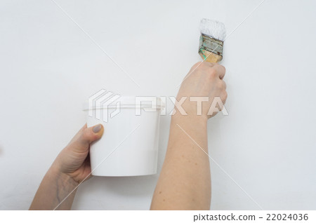 Paint can and brush in female hands Paint can and brush in female hands 22024036