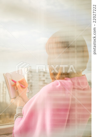 Woman making notes in the notebook vertical Woman making notes in the notebook vertical 22027222