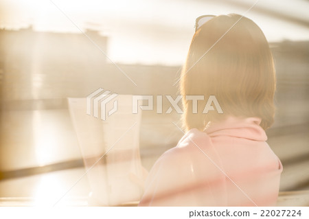Woman with magazine . View trough the blinds Woman with magazine . View trough the blinds 22027224