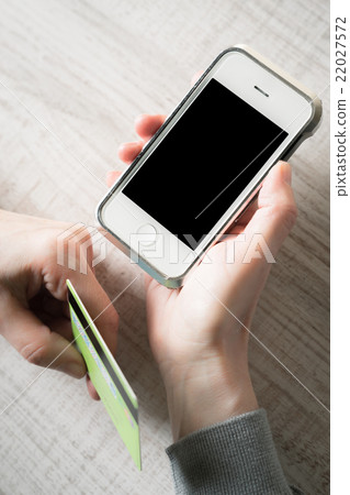 Hands with credit card and mobile phone vertical Hands with credit card and mobile phone vertical 22027572